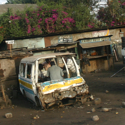 PHOTO BY JERRY SCHARF Men chat in the remants of a stripped minivan in Nairobi, Kenya. 